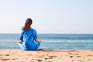empowered nurse meditating on the beach